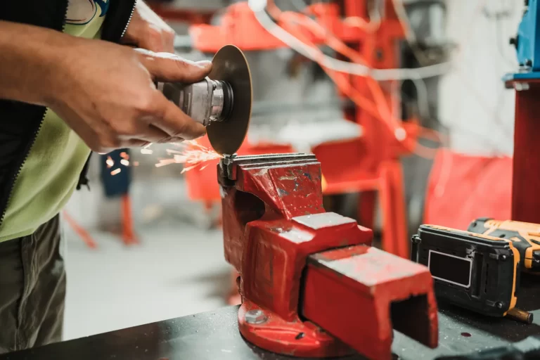 Worker working with a circular grinder on a metal with sparks